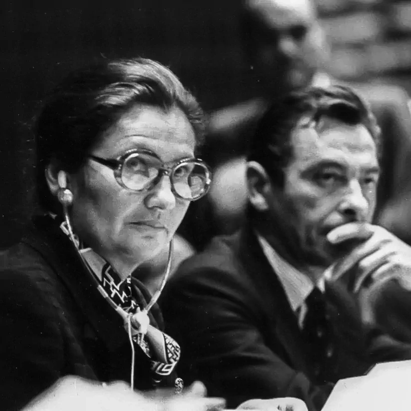 Simone Veil, lunettes et écouteur à l’oreille, assise à côté d’un homme. © Claude Truong-Ngoc, CC BY-SA 3.0