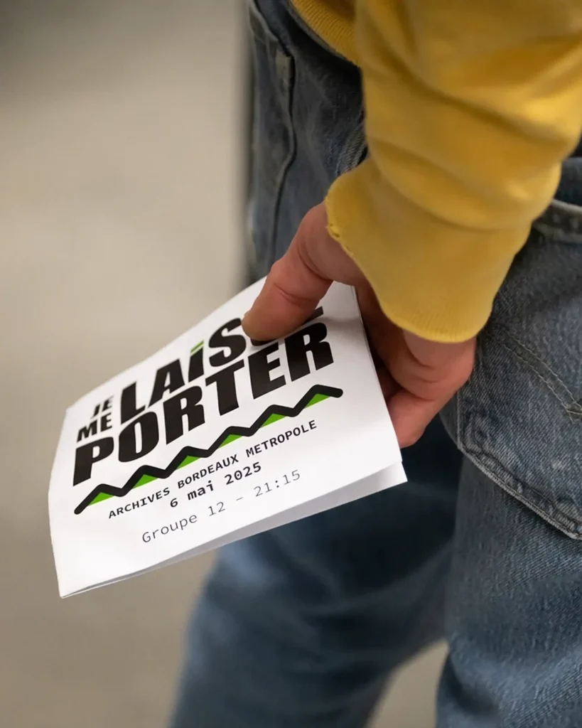 Une main tient un feuillet « Je me laisse porter – Archives Bordeaux Métropole, 6 mai 2025 ».