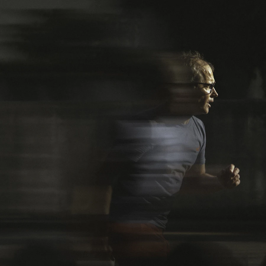 Dans « Scroll », un comédien à lunettes, de profil, dont la silhouette se brouille dans un flou de mouvement sur fond sombre.